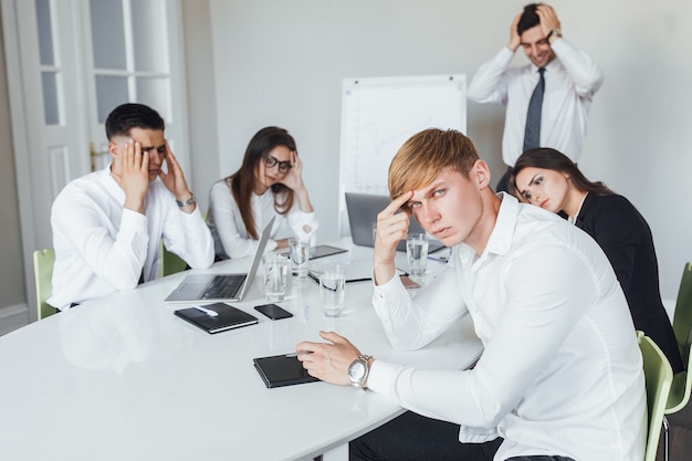 Young office workers are considering a new project in a modern conference room.