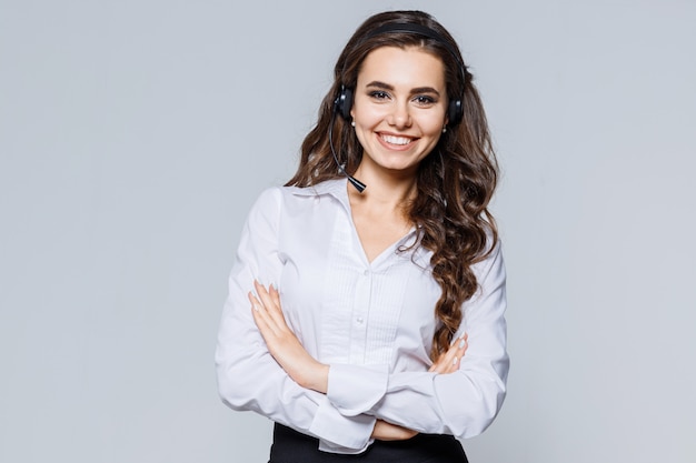 Photo young operator woman agent with headsets standing near gray. call center service.