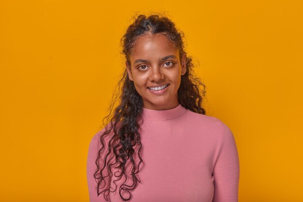 Photo young optimistic cute indian woman teenager stands in orange studio