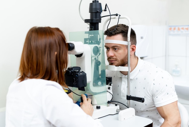 Young optometrist examining patients eyes Optician specialist eyesight testing