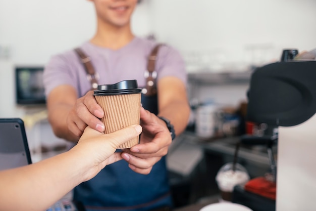 Young owner of coffee cafe service customer.