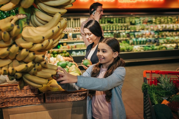 Young parents and daughter in grocery store