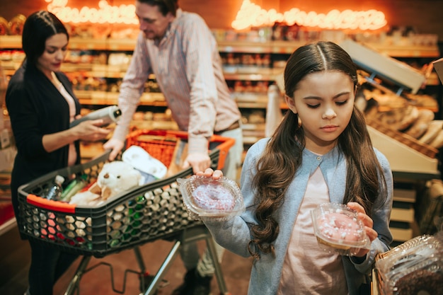 Young parents and daughter in grocery store