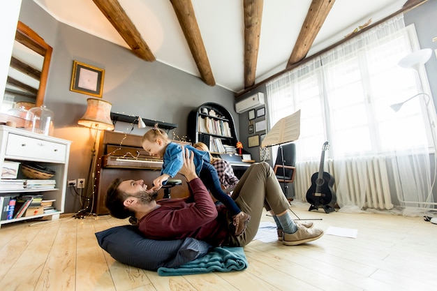 若い両親が部屋に娘と遊ぶ