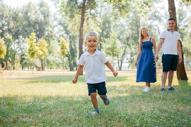 Young parents play in the park with their son