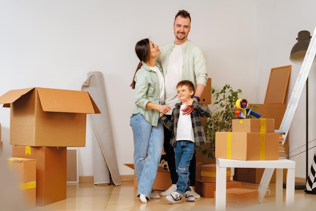 Young parents and son having fun during moving day to new house