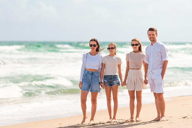 Young parents and two teenage girls on a beach holiday