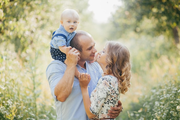 Young parents with little son in summer park