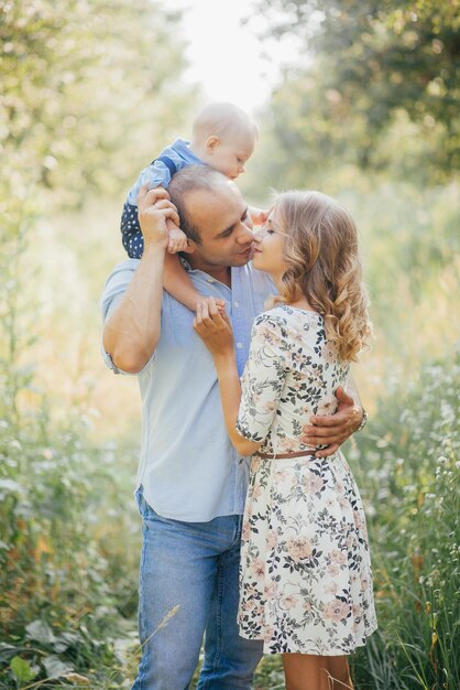 Young parents with little son in summer park