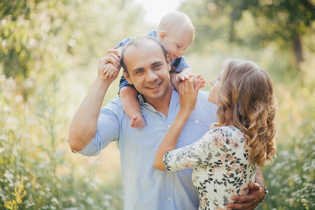 Young parents with little son in summer park