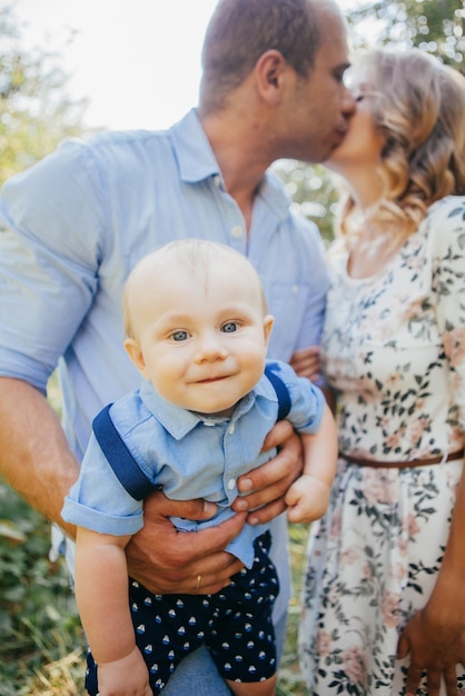 Young parents with little son in summer park