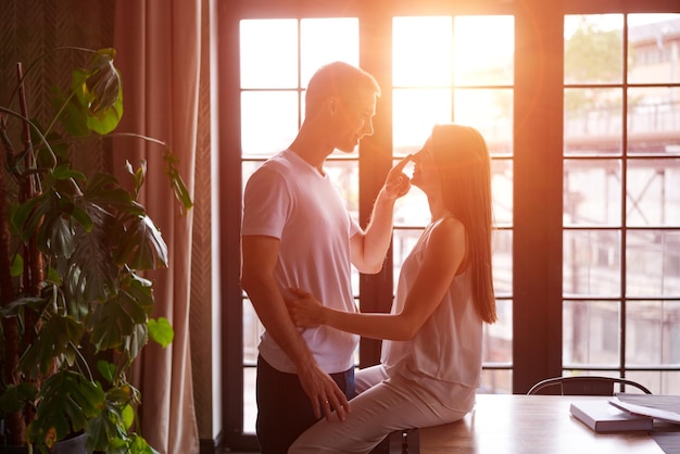 Young passionate couple in room against background window girl is sitting