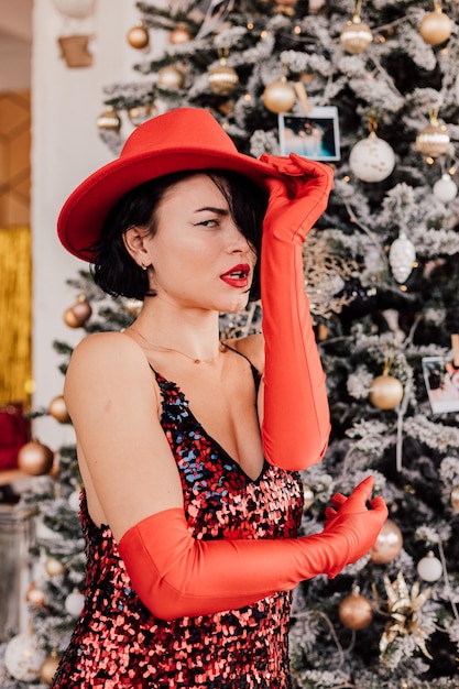 Young passionate girl posing near the Christmas tree