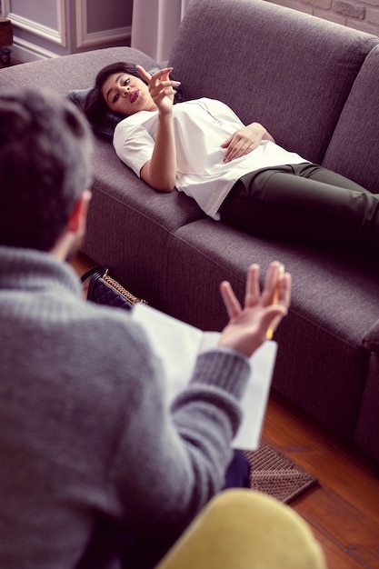 若い患者。彼女の医者に話している間彼女の指を持ち上げて素敵な美しい女性