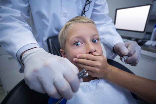 Молодой пациент напуган во время осмотра зубов