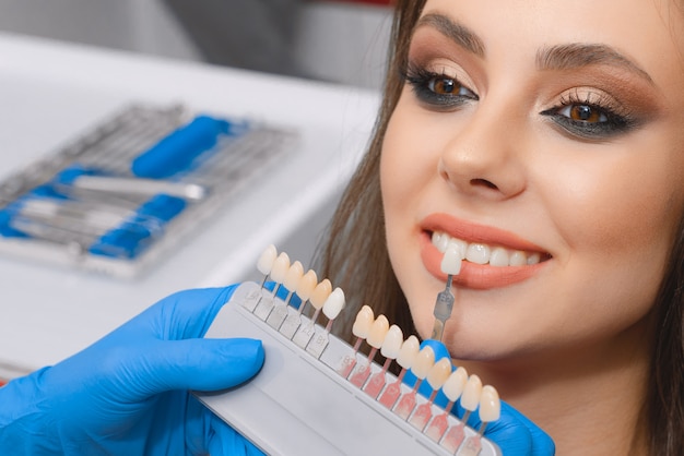 Foto il giovane paziente seleziona il colore del dente