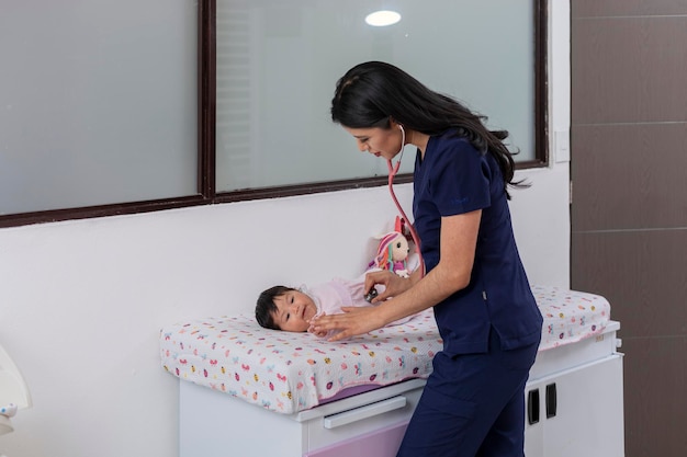 Young pediatric doctor checks baby with stethoscope