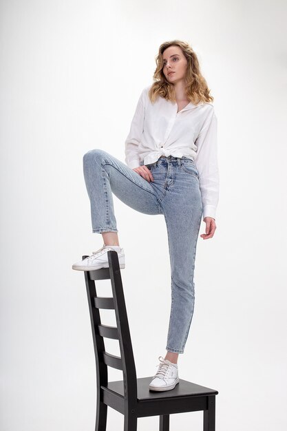 Young pensive caucasian girl poses in white shirt