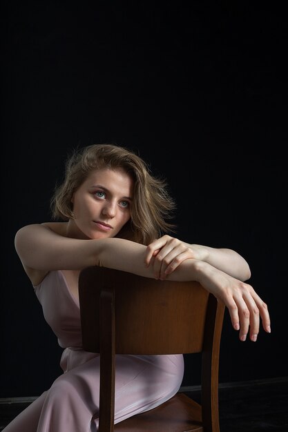 Young pensive caucasian woman with short hair posing in pink suit