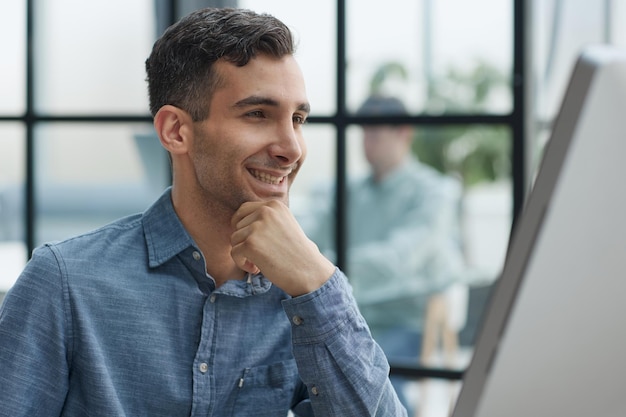 A young pensive man works in the office and thinks about something