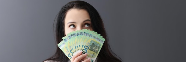 Young pensive woman holding lot of euro bills in front of her women shopping concept