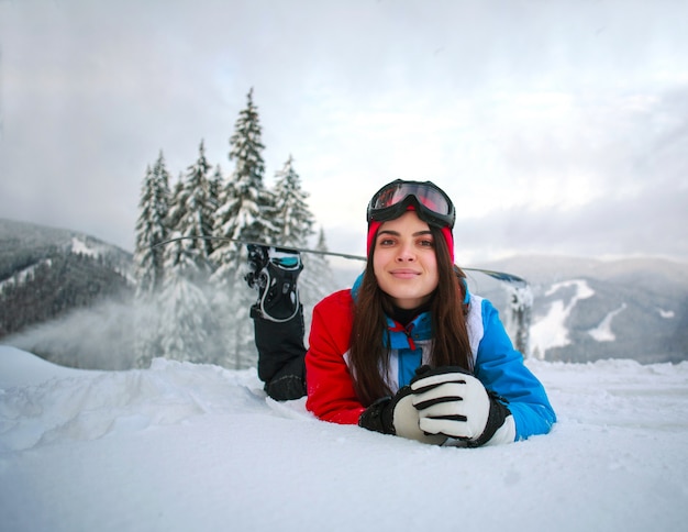 山の上に雪に覆われた森の冬の若い物思いにふける女性