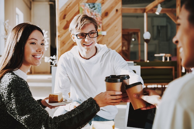 Photo young people are drinking coffee in office with friends