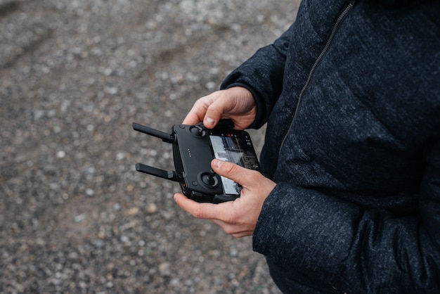 Young people are preparing a drone for flight. Remote control setup.