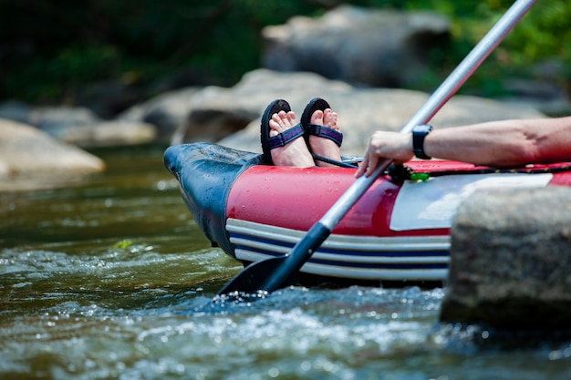 Young people are rafting in river.