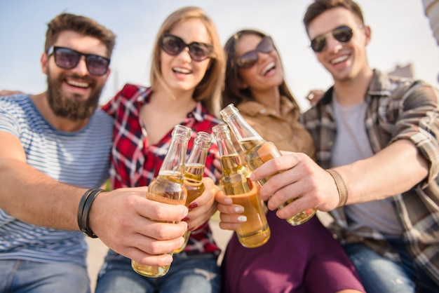 Young people clink glasses on nature.