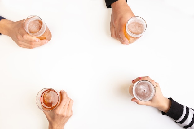 Young people drinking beers and having a good time on a white table