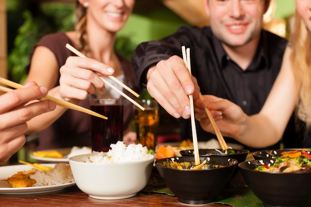 Young people eating in Thai restaurant