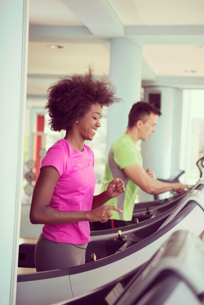 young people exercisinng a cardio on treadmill running chine in modern gym