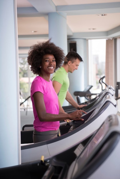 young people exercisinng a cardio on treadmill running chine in modern gym