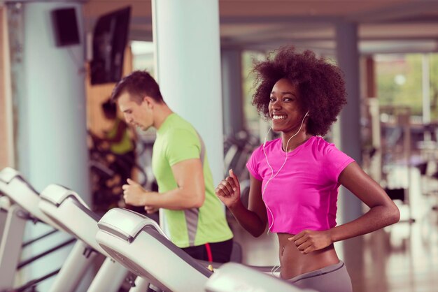 young people exercisinng a cardio on treadmill running machine in modern gym