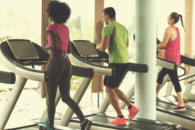 young people exercisinng a cardio on treadmill running machine in modern gym