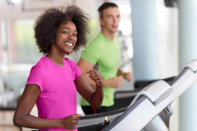 young people exercisinng a cardio on treadmill running machine in modern gym