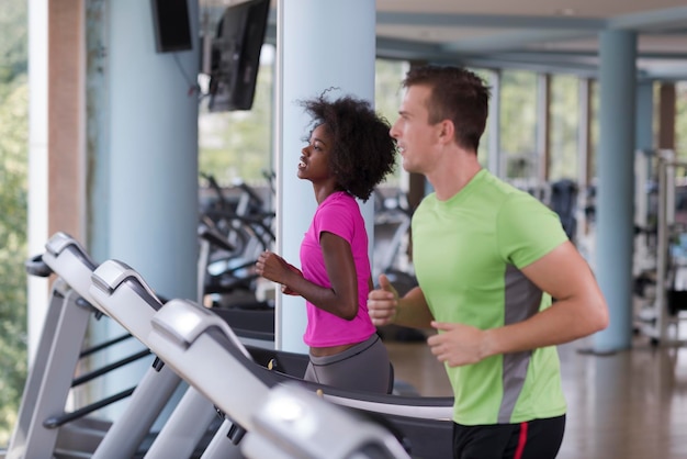 Photo young people exercisinng a cardio on treadmill running machine in modern gym