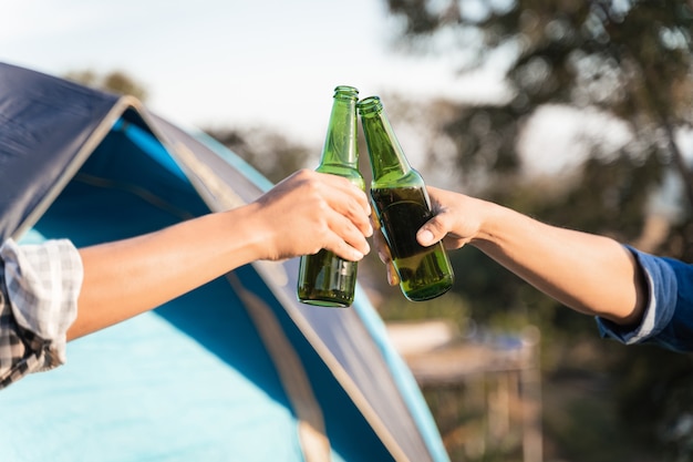 Young people go summer camping in the national park with beer\
and a small guitar party free photo