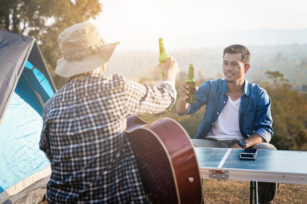 Young people go summer camping in the national park with beer\
and a small guitar party free photo