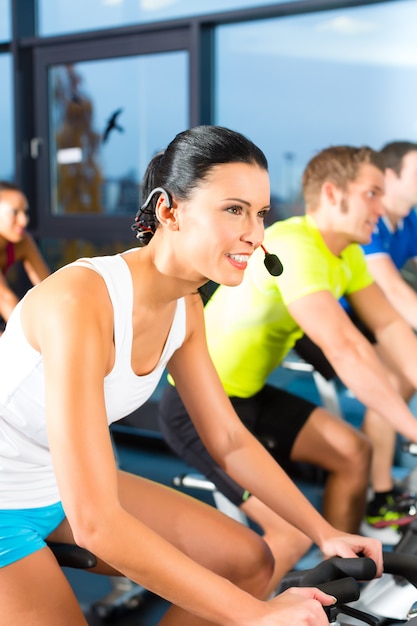 Giovani - gruppo di donne e uomini - facendo sport spinning in the gym for fitness