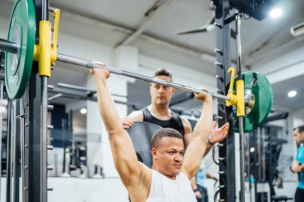 Young people in the gym training weights.