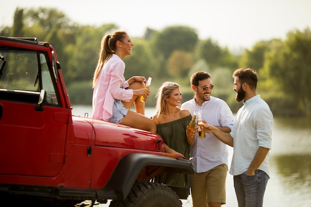 Young people having fun in convertible car by river