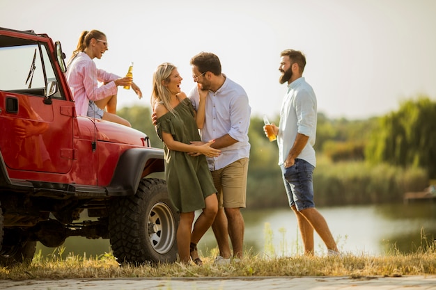 Young people having fun in convertible car by river