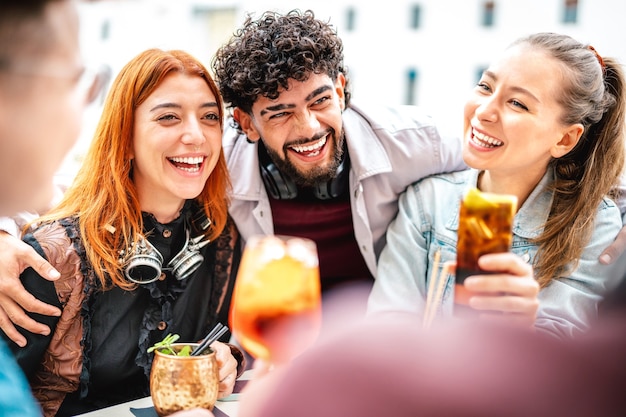 Young people having fun drinking at open air bar after work