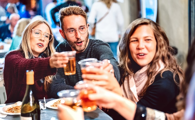 Young people having fun toasting white wine at street food festival