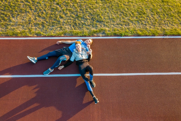 young people laying on running track