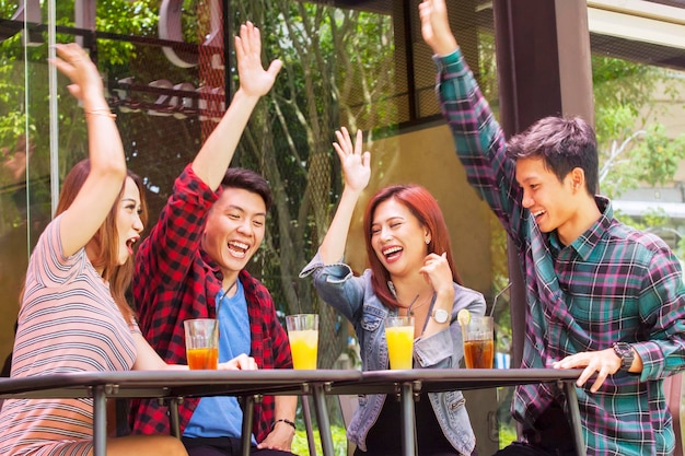 Young people lifting hands together in restaurant