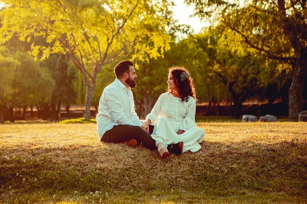 Young people in love sitting in a park at sunset