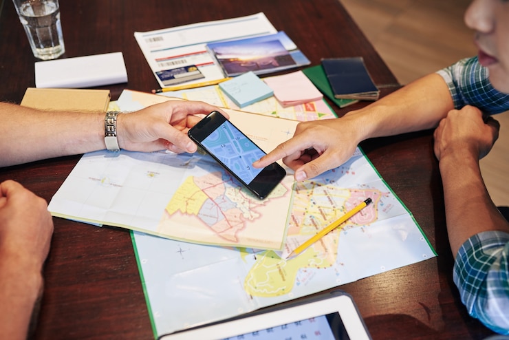 Photo young people planning trip, they are checking paper maps and online application on smartphone